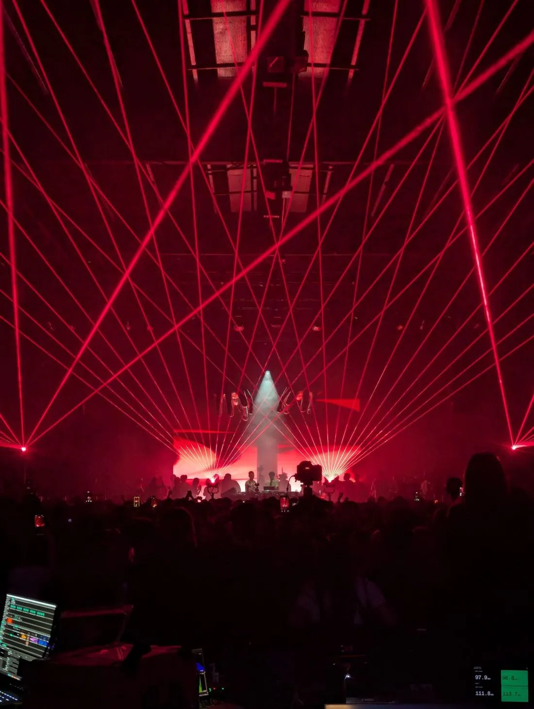 Red lasers over a packed room, seen from front of house