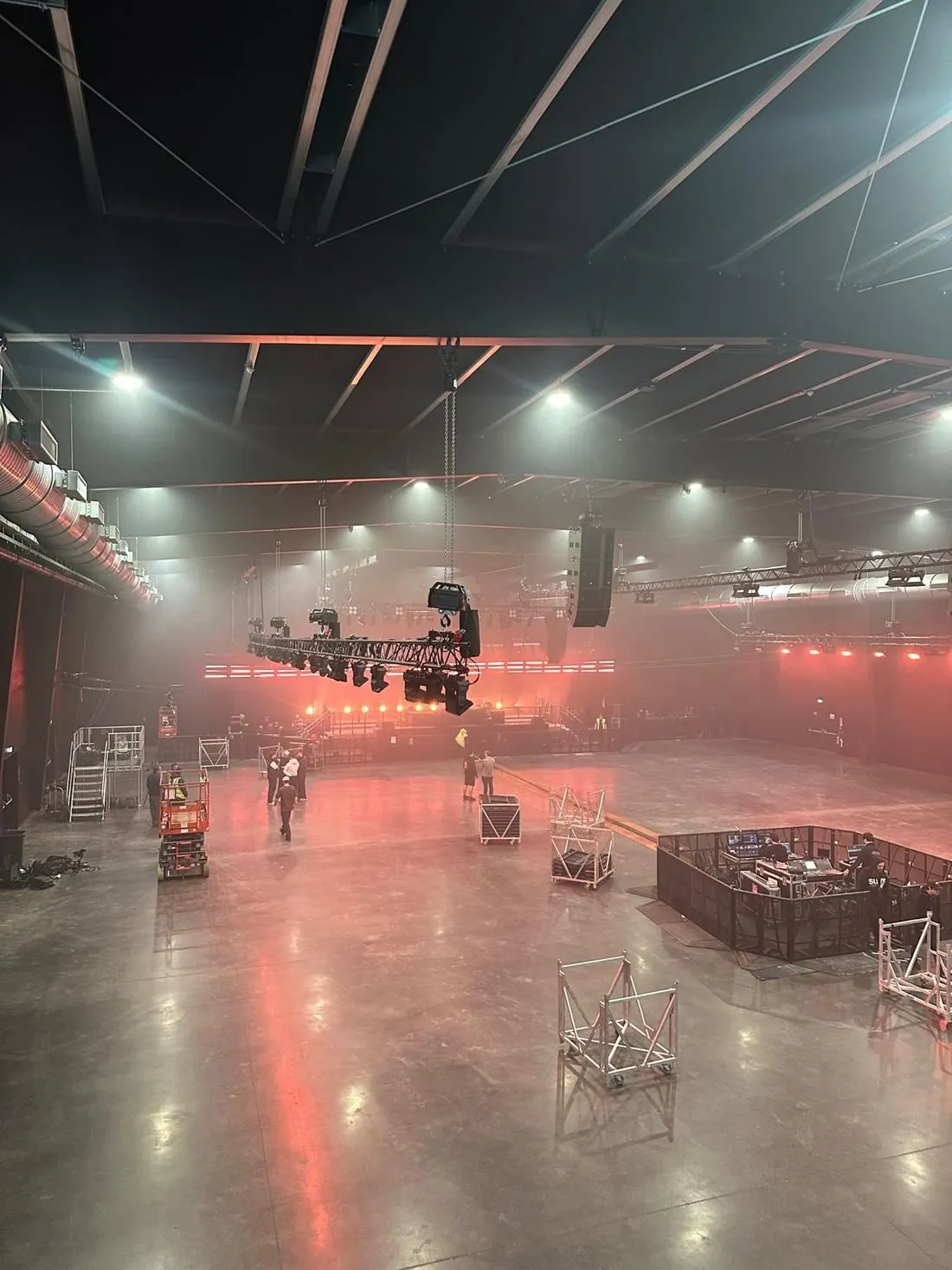 Empty venue during the build, truss being flown and FOH riser set