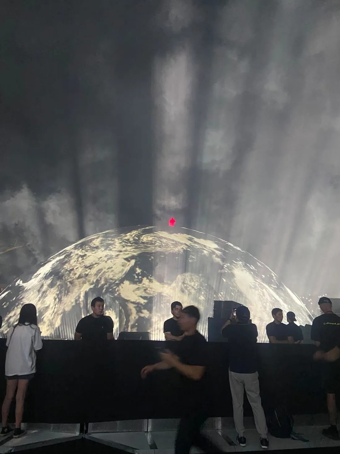 Earth projected on the dome stage on Ye's 2026 stadium tour, crew at the barrier